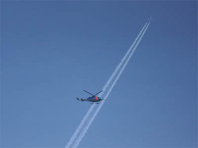 青空の飛行機雲と横切るヘリコプター