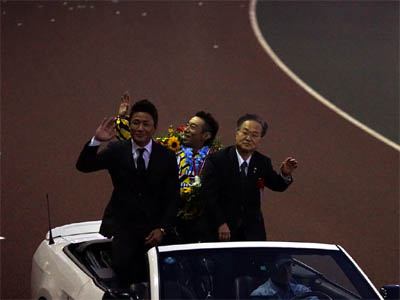 オープンカーに乗って場内を半周する永井大介選手と川口市長と元K1選手の魔裟斗