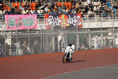 試走でコースを周回する岡谷美由紀選手と応援の垂れ幕