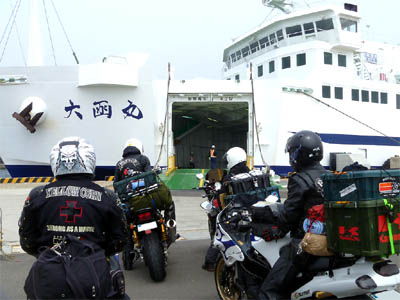 大間港フェリーターミナルに接岸している津軽海峡フェリー「大函丸」と車両甲板への乗船待ちをしているバイクとライダー