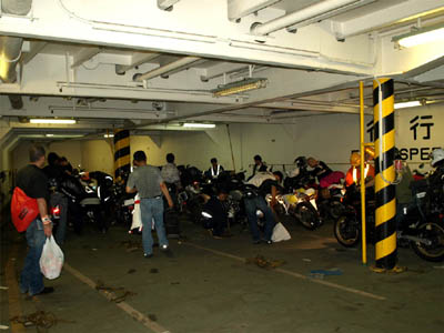 商船三井フェリー「さんふらわあさっぽろ」の車両甲板で船首に駐車したバイクと荷降ろし中のライダー達