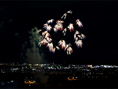 昭和記念公園の花火大会で打ち上げられた花火と立川市内の夜景