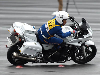全国白バイ安全運転競技大会の傾斜走行操縦競技でパーシャルスロットルでＲの大きな中速の右カーブを旋回する白バイ