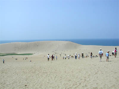 8月の真夏の炎天下を歩く鳥取砂丘の観光客