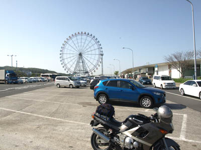 神戸淡路鳴門自動車道の淡路SAの駐車場の停めたバイクと遠くに見える観覧車