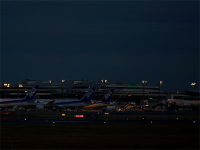 夜の成田空港と第１ターミナルのスポットに駐機中の機体