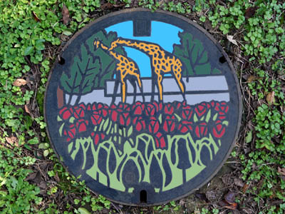 羽村市動物公園のキリンとチューリップが描かれたデザインマンホール（カラーマンホール）