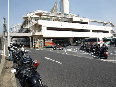 混雑しているため東京湾アクアラインの海ほたるパーキングエリアの駐車場の片隅に停まっているバイク