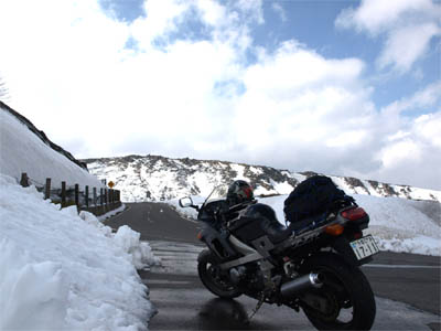 在一条日本路的摩托车有在路的雪的