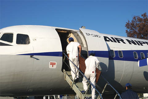 Equipe de eventos para armazenar equipamentos no avião do YS-11