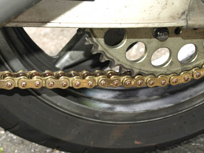 Use a waste cloth to remove excess oil from the chain