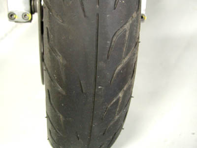 Neumático desgastado de la motocicleta con señal de deslizamiento