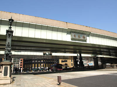 国道１号線の起点である日本橋の上に架かる高速道路と「日本橋」の鉄製標識