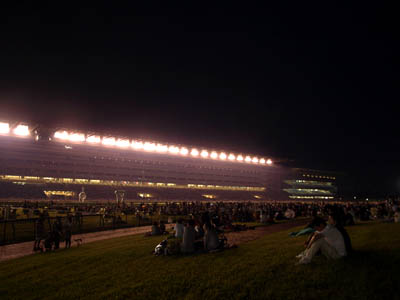 スタンドの照明に照らされた花火大会開催前の夜の東京競馬場（府中競馬場）