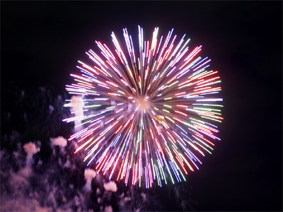 昭和記念公園の花火大会で打ち上げられたカラフルな花火とその光に照らされた打ち上げ時の煙