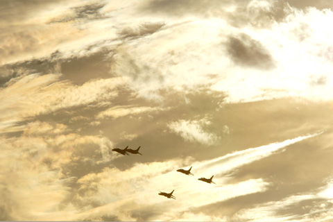 入間基地航空祭のリハーサルで黄金色の夕焼けの空を飛行するT-4練習機