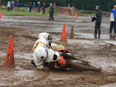 大雨のオフロードコースで転倒する白バイ隊員