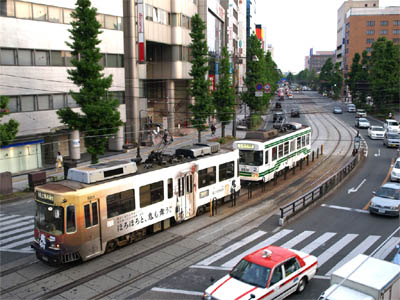 熊本市外の道路に並走している路面電車と軌道
