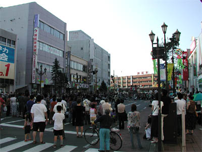 「くしろ港まつり」の開催で通行止めになった釧路駅前の道路と路上に集まる観客