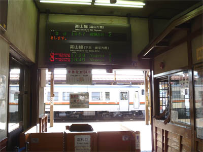 高山本線の高山駅の改札口と列車の発車時刻を示す電光表示板