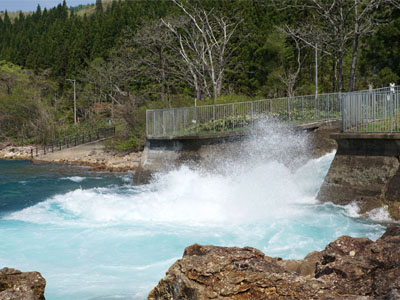田沢湖発電所の水路から田沢湖に勢いよく流れ込む水流と水しぶき