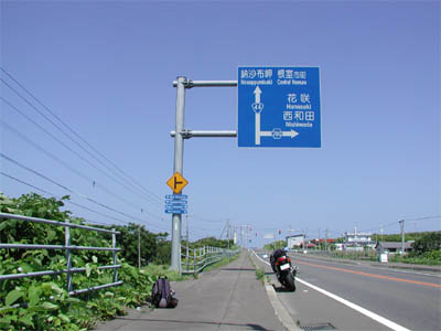 根室市街地へと続く国道44号線の道路標識と路肩に停めたバイク