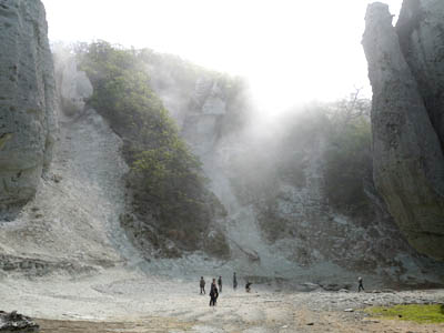 高くそびえ立つ仏ヶ浦の奇岩と小さく見える観光客