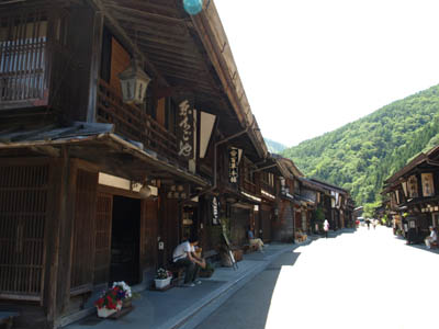 中山道の奈良井宿のメインストリート沿いに並ぶ古い木造の家屋と店の看板